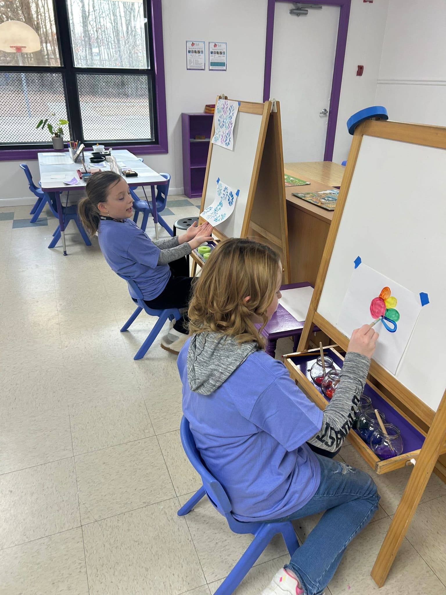 Children painting at easels in the studio