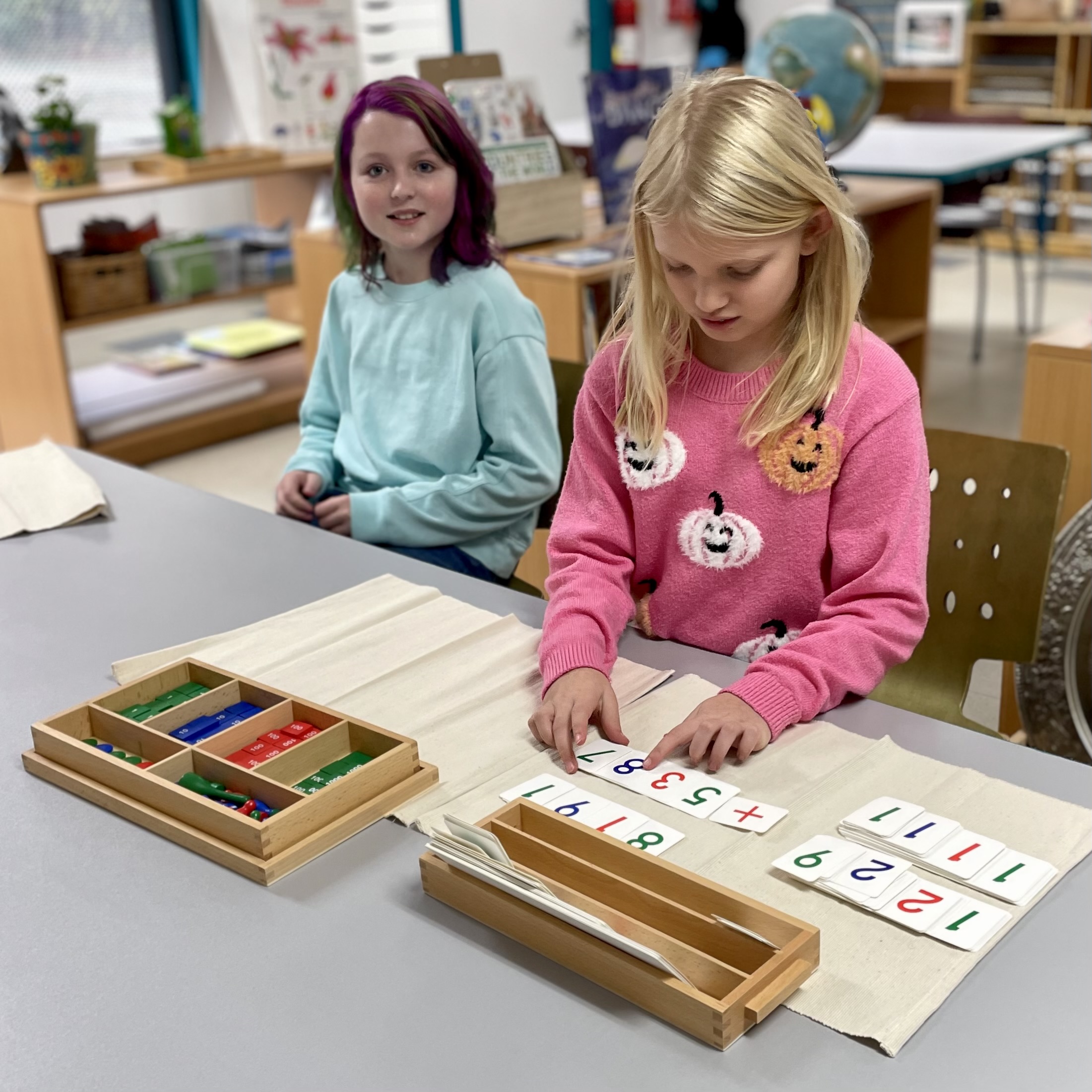 Students working with Montessori math materials in the classroom