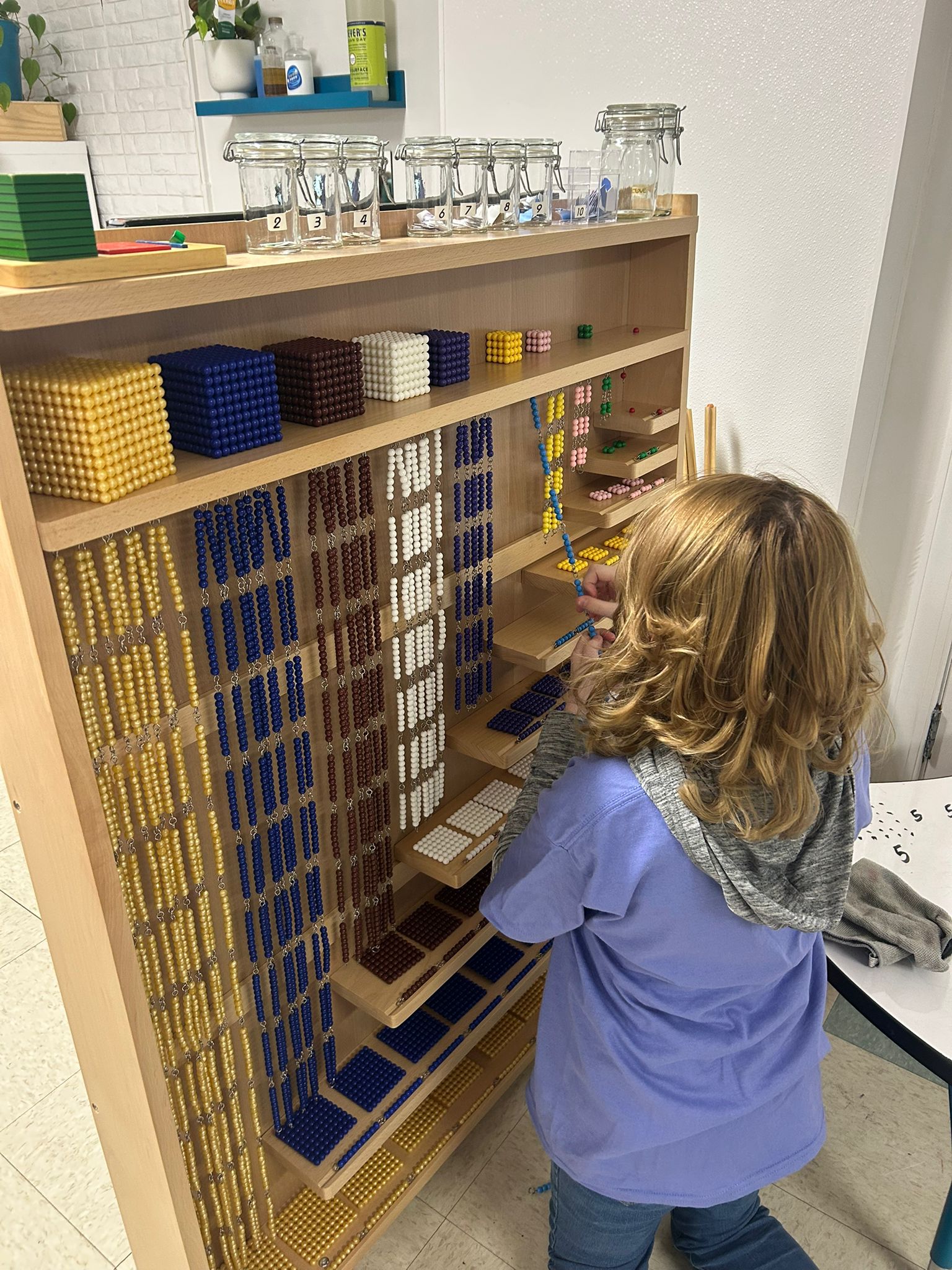 Child working with Montessori bead cabinet